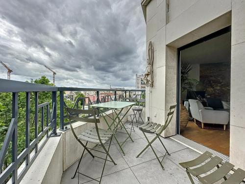 a balcony with a table and chairs on a building at Classy apartment with terrace in Saint-Ouen