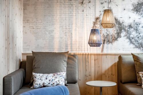 a living room with a couch and two pendant lights at Alpenromantik-Hotel Wirlerhof in Galtür