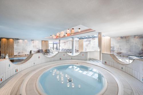 a large bathroom with a tub in the middle at Alpenromantik-Hotel Wirlerhof in Galtür