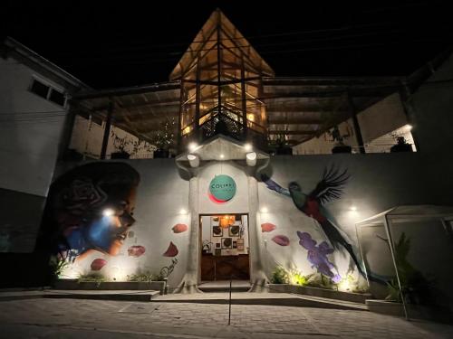 a building with a painting on the side of it at night at Grupo Hotelero Colibri in Panajachel