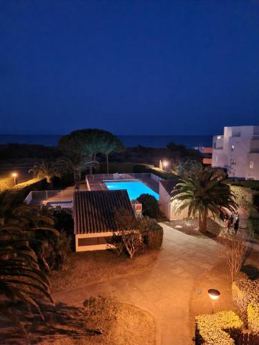 - une vue sur la piscine la nuit dans l'établissement MAGNIFIQUE vue mer pour ce T2 avec piscine, à Saint-Cyprien