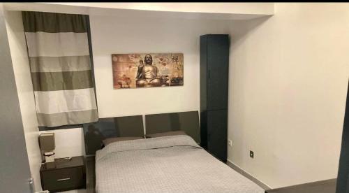 - une petite chambre avec un lit et une photo sur le mur dans l'établissement Appartement de village complet tout confort, à Noves