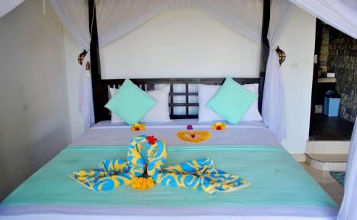a bed in a tent with towels on it at Titi Sedana Homestay in Amed