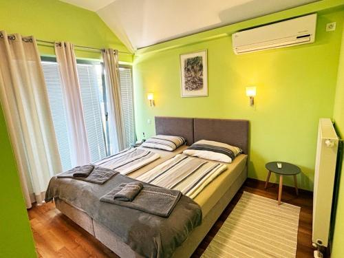 a bedroom with a large bed with green walls at Villa Dambo mit Pool , 4 Sterne in Grkavešćak