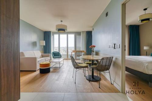 une chambre d'hôtel avec un lit, une table et des chaises dans l'établissement Le Lumineux - À Auteuil - 361B, à Paris