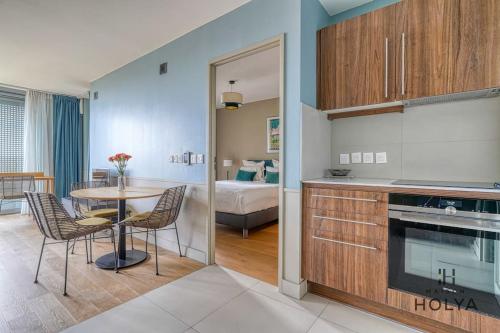 une cuisine et une salle à manger avec une table et une chambre dans l'établissement Le Lumineux - À Auteuil - 361B, à Paris