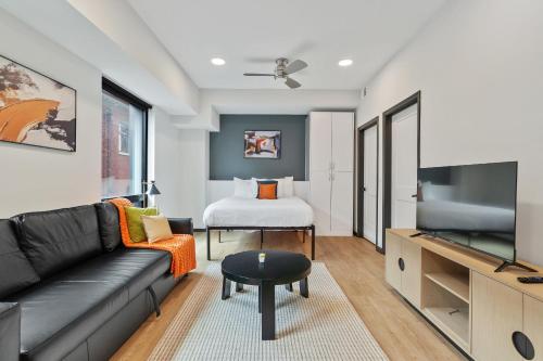 a living room with a couch and a flat screen tv at CozySuites on Mass with garage parking #14 in Indianapolis