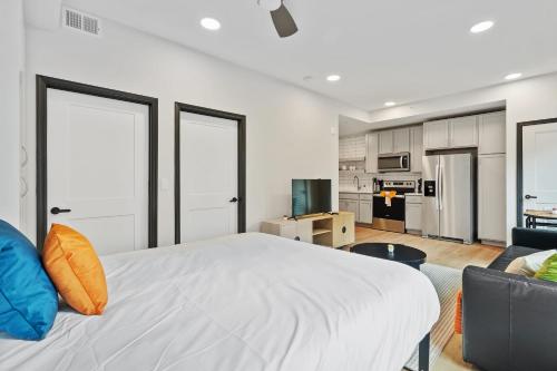 a bedroom with a large white bed and a couch at CozySuites on Mass with garage parking #14 in Indianapolis