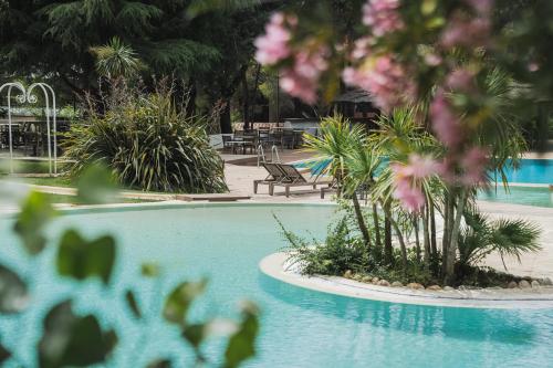 a swimming pool with pink flowers in a resort at Setclub Hôtel & Spa Aix-en-Provence in Aix-en-Provence