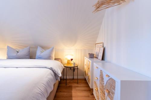 een slaapkamer met een wit bed en een tafel bij Studio - Kleiner Ostsee Hof in Großenbrode