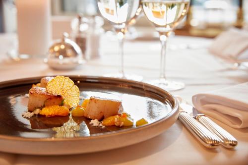 a plate of food on a table with wine glasses at Hotel Schweizerhof Zürich in Zürich