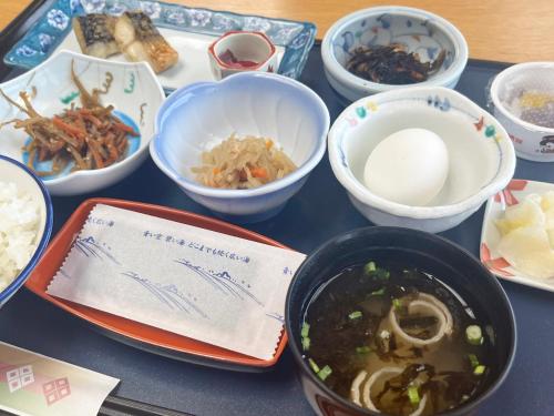 a table with bowls and plates of food on it at 瀬波 清波温泉 in Senami