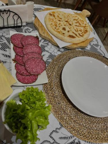 a table topped with meat and a plate of food at View Racha in Ambrolauri