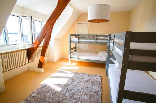 une chambre avec deux lits superposés et un tapis dans l'établissement -AVEL DRO- Belle maison familiale vue mer corniche, à Concarneau