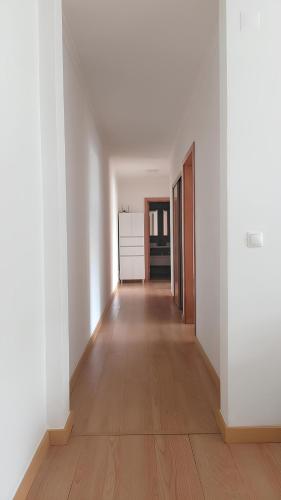 an empty hallway with white walls and wooden floors at Ponta Delgada 3 Bedroom Apartment in Ponta Delgada