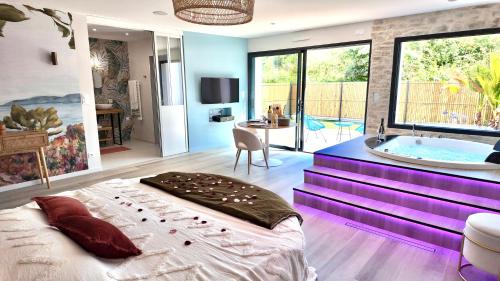 - une chambre avec une baignoire et un lit dans une pièce dans l'établissement Les Suites du Payré - Suite Romance, à Saint-Hilaire-de-Talmont