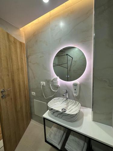 a bathroom with a sink and a mirror at Hotel Arberia in Tirana