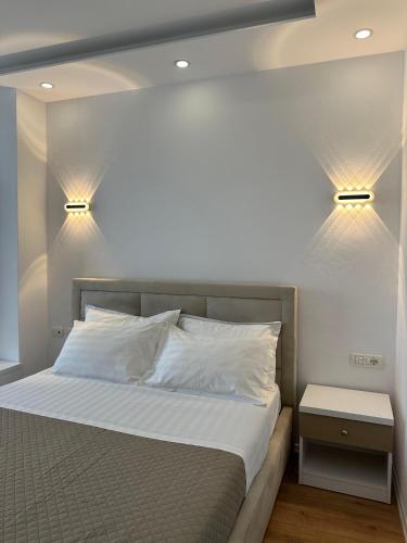 a bedroom with a bed with two lights on the wall at Hotel Arberia in Tirana