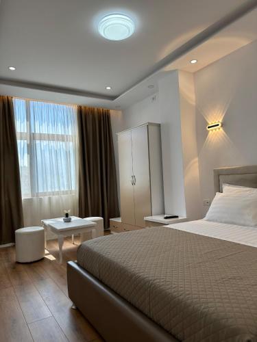a bedroom with a large bed and a table at Hotel Arberia in Tirana