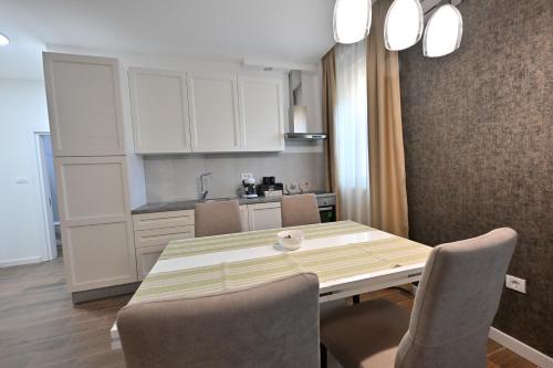 a kitchen with a table and chairs in a room at Lux Apartmani Novi Park in Vrdnik
