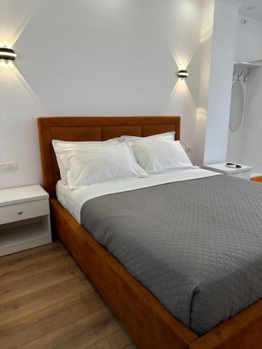 a bed in a bedroom with two night stands and two lamps at Hotel Arberia in Tirana