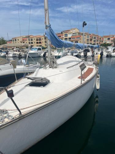 un voilier blanc amarré dans un port avec d'autres bateaux dans l'établissement Voilier et plage, au Cap d'Agde