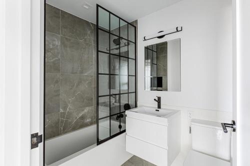 een witte badkamer met een wastafel en een spiegel bij Blueground Upper East Side fully equipped NYC-1545 in Brooklyn