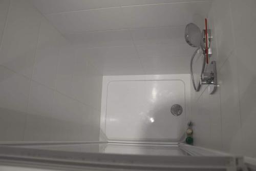 ein weißes Waschbecken in einer weißen Wand mit einem Telefon in der Unterkunft Chambre privée proche Accord Arena et avec metro 20 min de la Tour Eiffel in Paris