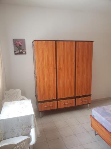 a bedroom with a wooden cabinet and a bed at Chez Nafy in Saint-Louis