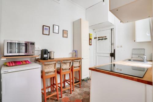 - une cuisine avec un comptoir et quelques chaises dans l'établissement GuestReady - Charmant Apt pour 2 au Cœur de Paris, à Paris