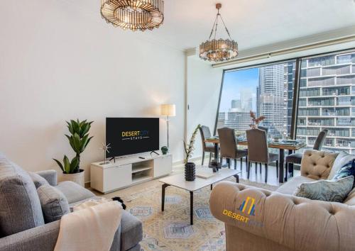 a living room with a tv and a dining room at Luxurious 2 Bed Next to Burj Khalifa, Hosted by Desert City Stays in Dubai