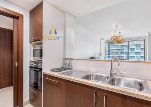 a kitchen with a sink and a microwave at Luxurious 2 Bed Next to Burj Khalifa, Hosted by Desert City Stays in Dubai