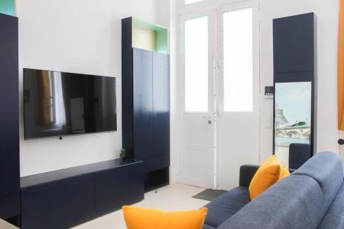 un salon avec un canapé bleu et une télévision dans l'établissement studio parisien renovated - close to the Pantheon, à Paris