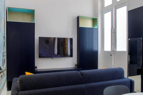 un salon avec un canapé bleu et une télévision dans l'établissement studio parisien renovated - close to the Pantheon, à Paris