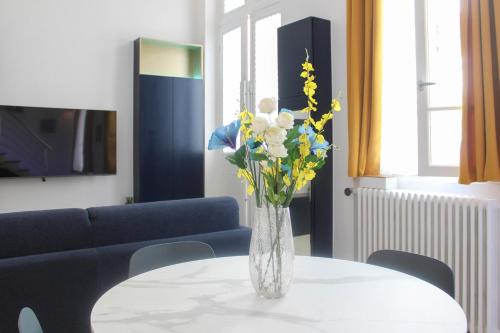 un vase de fleurs assis sur une table dans l'établissement studio parisien renovated - close to the Pantheon, à Paris