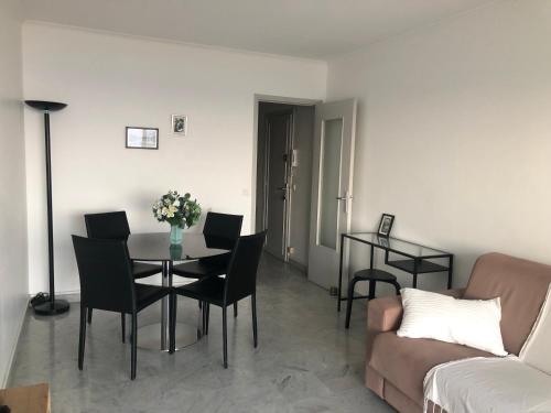 un salon avec une table, des chaises et un canapé dans l'établissement MENTON APPARTEMENT VUE MER 2 Pièces, à Menton