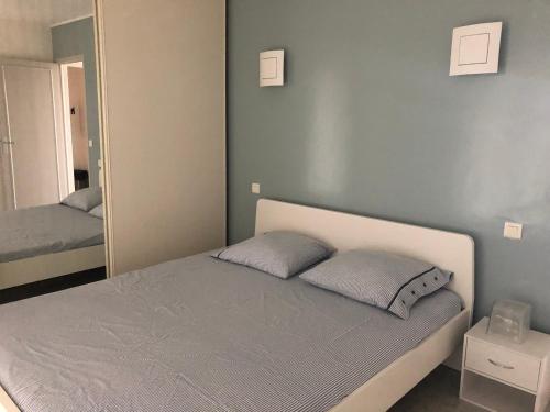 une chambre avec un lit et un grand miroir dans l'établissement MENTON APPARTEMENT VUE MER 2 Pièces, à Menton