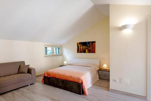 a bedroom with a bed and a couch at Casa Alle Porte Della Costiera in Cava deʼ Tirreni
