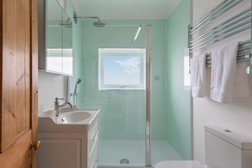 een badkamer met een wastafel en een douche bij Sea Spray Cottage by Bloom Stays in Sandgate