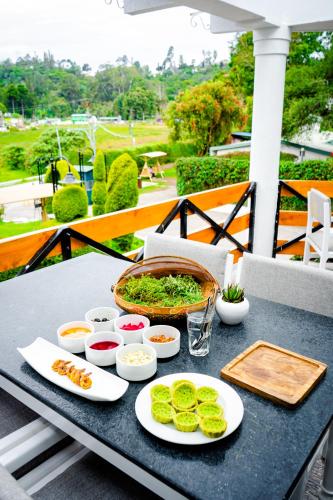 a table with plates of food on a balcony at Sterling Kodai Lake in Kodaikānāl