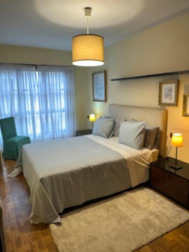 a bedroom with a large bed and a lamp at Duplex Arriondas in Arriondas