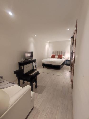 a bedroom with a bed and a desk and a piano at Grupo Hotelero Colibri in Panajachel