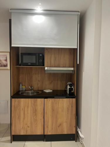 a small kitchen with a sink and a microwave at AppartHôtel Elite Spa in Forbach