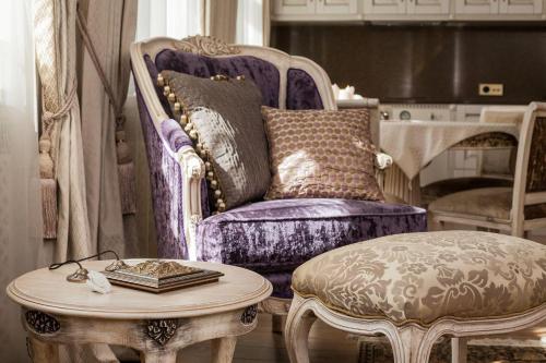 un salon avec une chaise et une table dans l'établissement Boutique Classic Apartment in Kaunas Center, à Kaunas