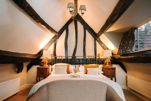 a bedroom with a bed with a cat sitting on it at The Castle Inn in Castle Combe
