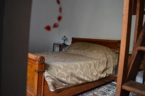 - une chambre avec un lit doté d'un cadre en bois dans l'établissement LA PROVIDENCE, à Le Noyer