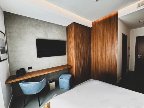a bedroom with a bed and a tv on a wall at J Maluni City Hotel in Rome