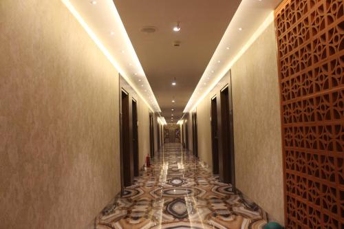 a corridor of a hotel with a long hallway with a tile floor at Hotel Madhuban in Silvassa