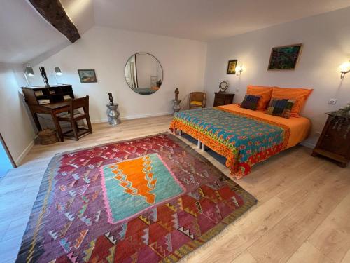 - une chambre avec un lit, un tapis et un miroir dans l'établissement Aux couleurs de Commarin CHAMBRES d'hôtes, à Commarin