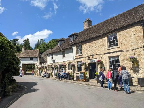 a group of people standing on the side of a street at The Castle Inn in Castle Combe
